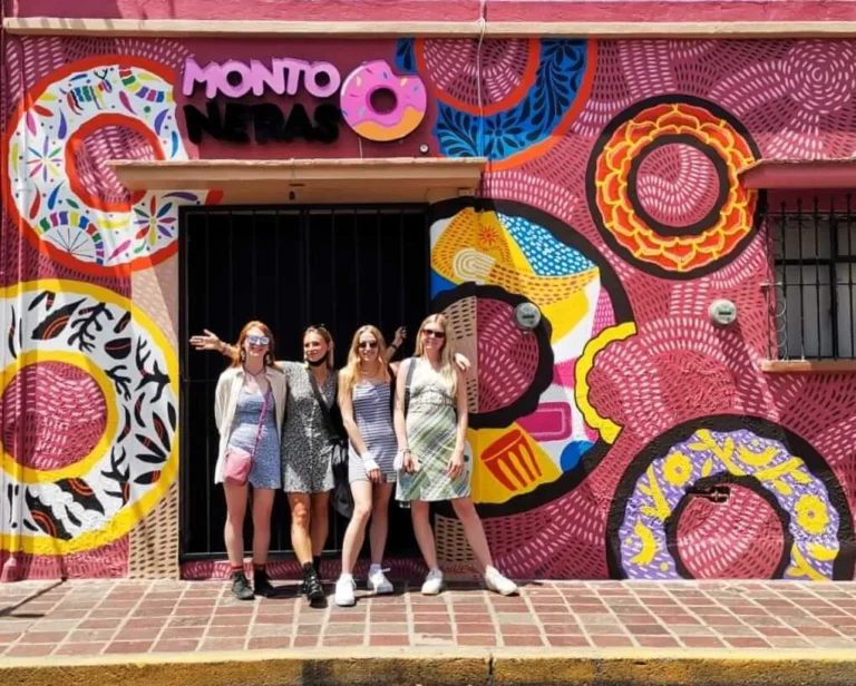 Oaxaca art walk Tour with cultura distinta. Group picture outside of a colourfully painted house