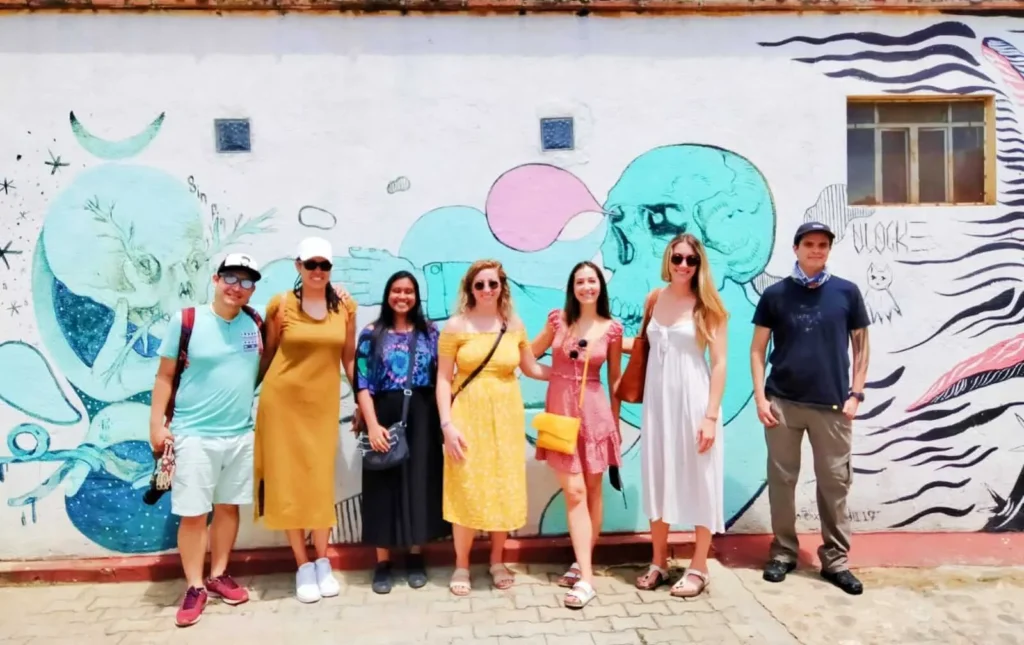 Oaxaca art walk Tour with cultura distinta. Group picture outside of a colourfully painted house