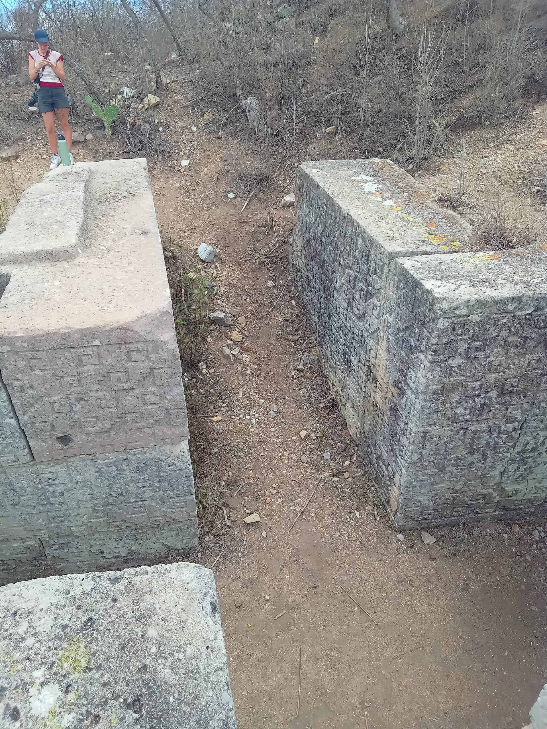 Women on top of a cruciform tomb with pre Hispanic carvings near Oaxaca